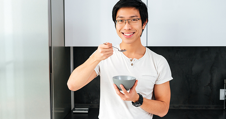 healthy man with glasses, eating from a bowl