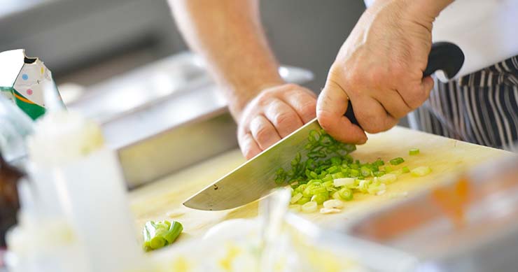 chef's hand chopping up celery