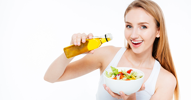 girl putting sauce on her salad