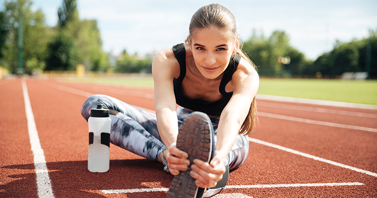 fit girl stretching in the racetrack