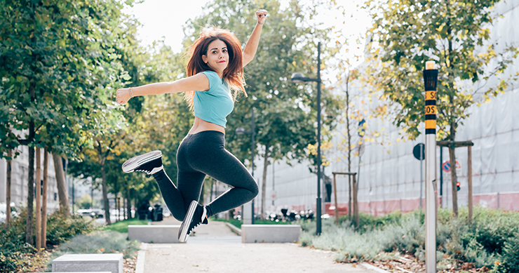 fit happy girl jumping on the street