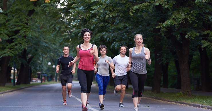 adults jogging with friends in the road