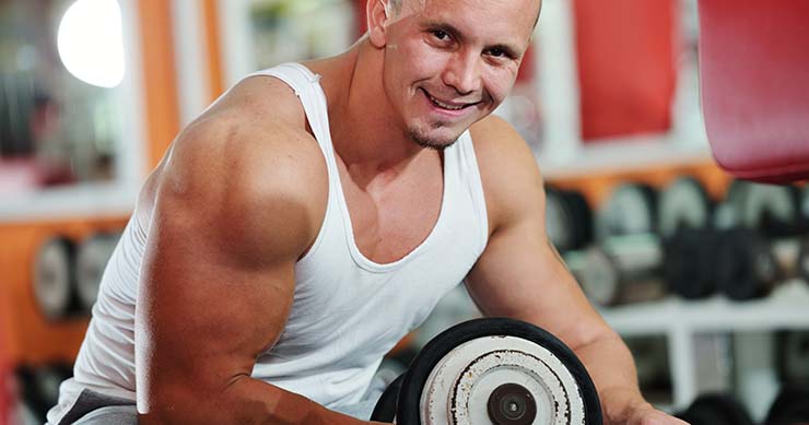 fit man working out using dumbbells at the gym