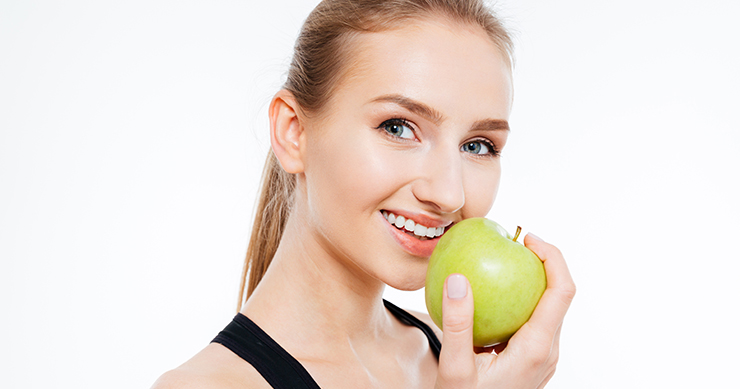 Beautiful Fit Girl eating green apple