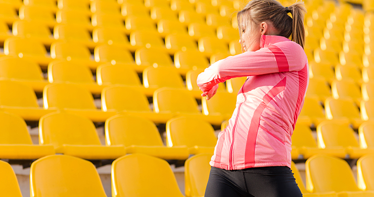 fit girl stretching with yellow benches in the background