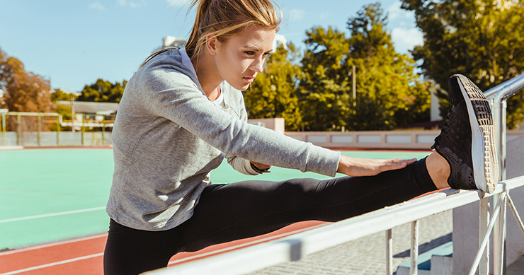 Fit Girl Stretching legs in the tracks